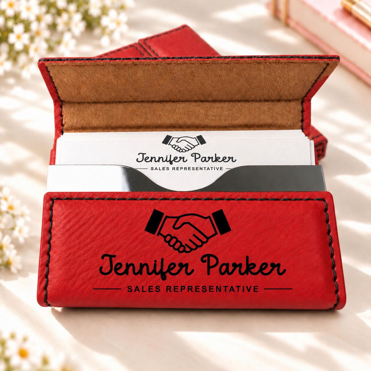Red business card holder engraved with a handshake design, name and title