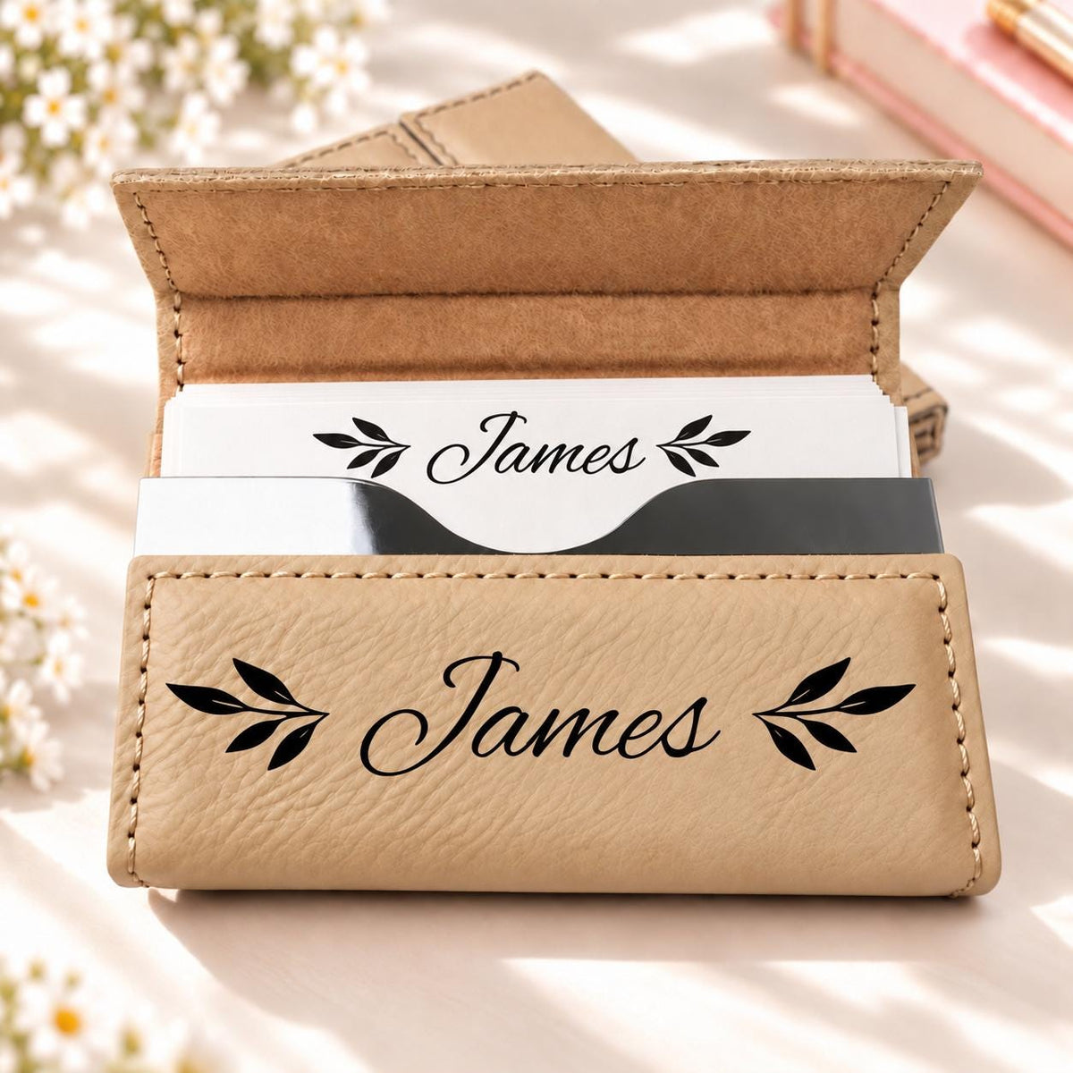 Light tan business card holder engraved with a name and leaf sprigs