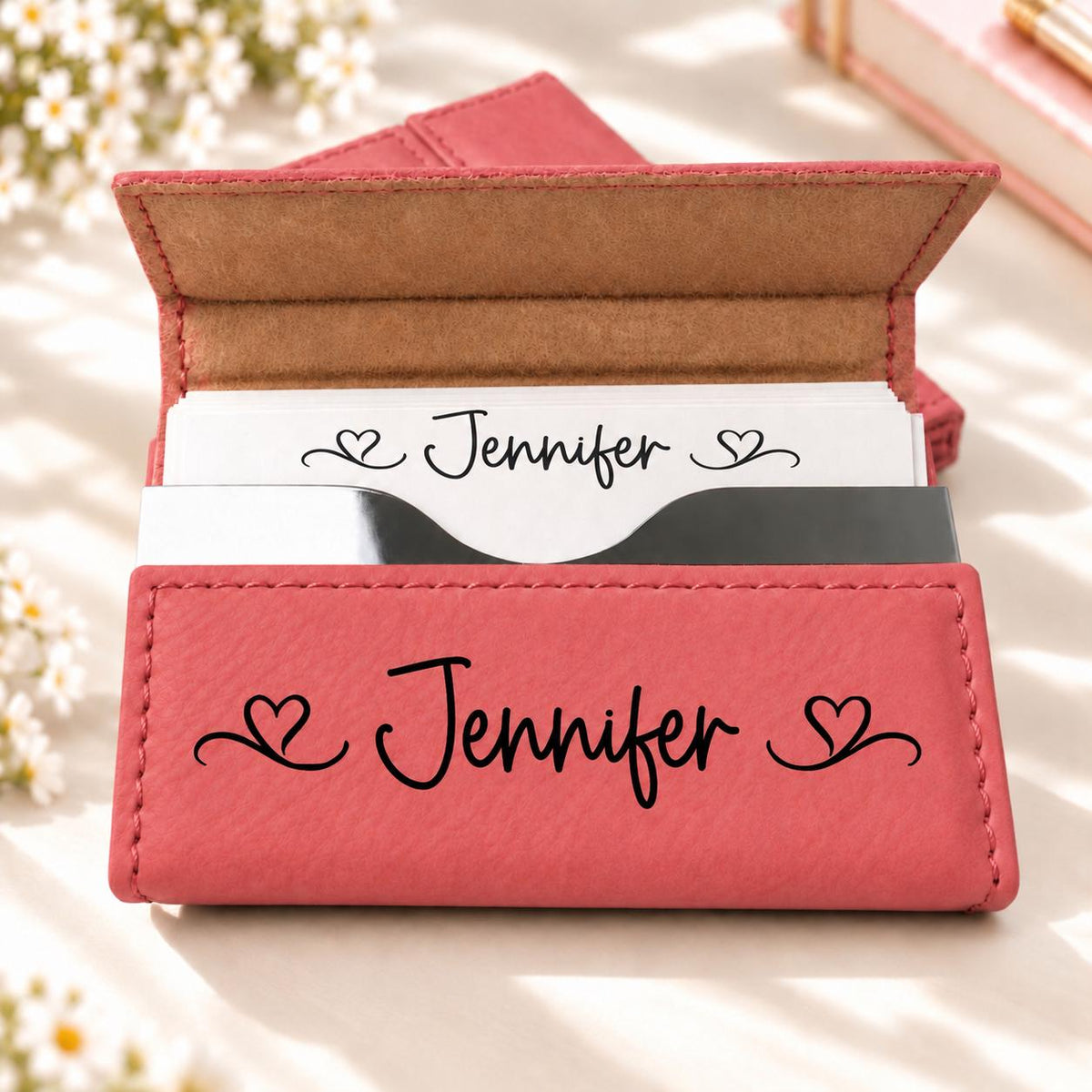 Pink business card holder engraved with a name and scroll hearts