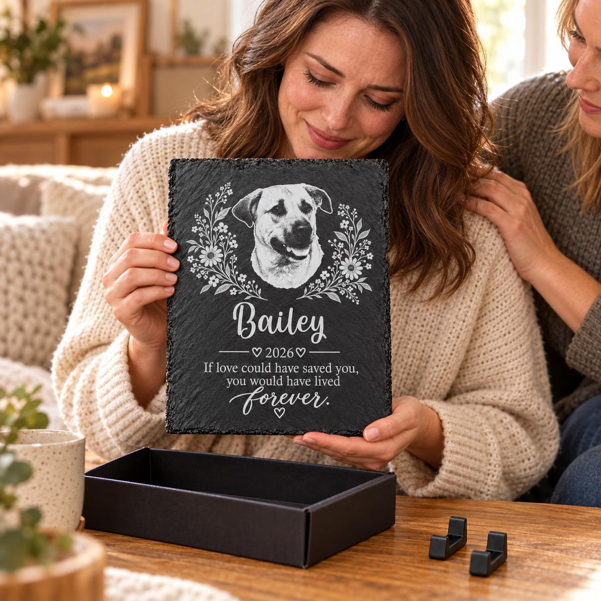 Woman holding a personalized dog memorial slate plaque with its black gift box