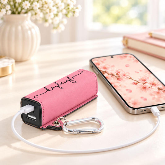 Personalized leatherette power bank in pink engraved with the name Kayleigh, charging a phone