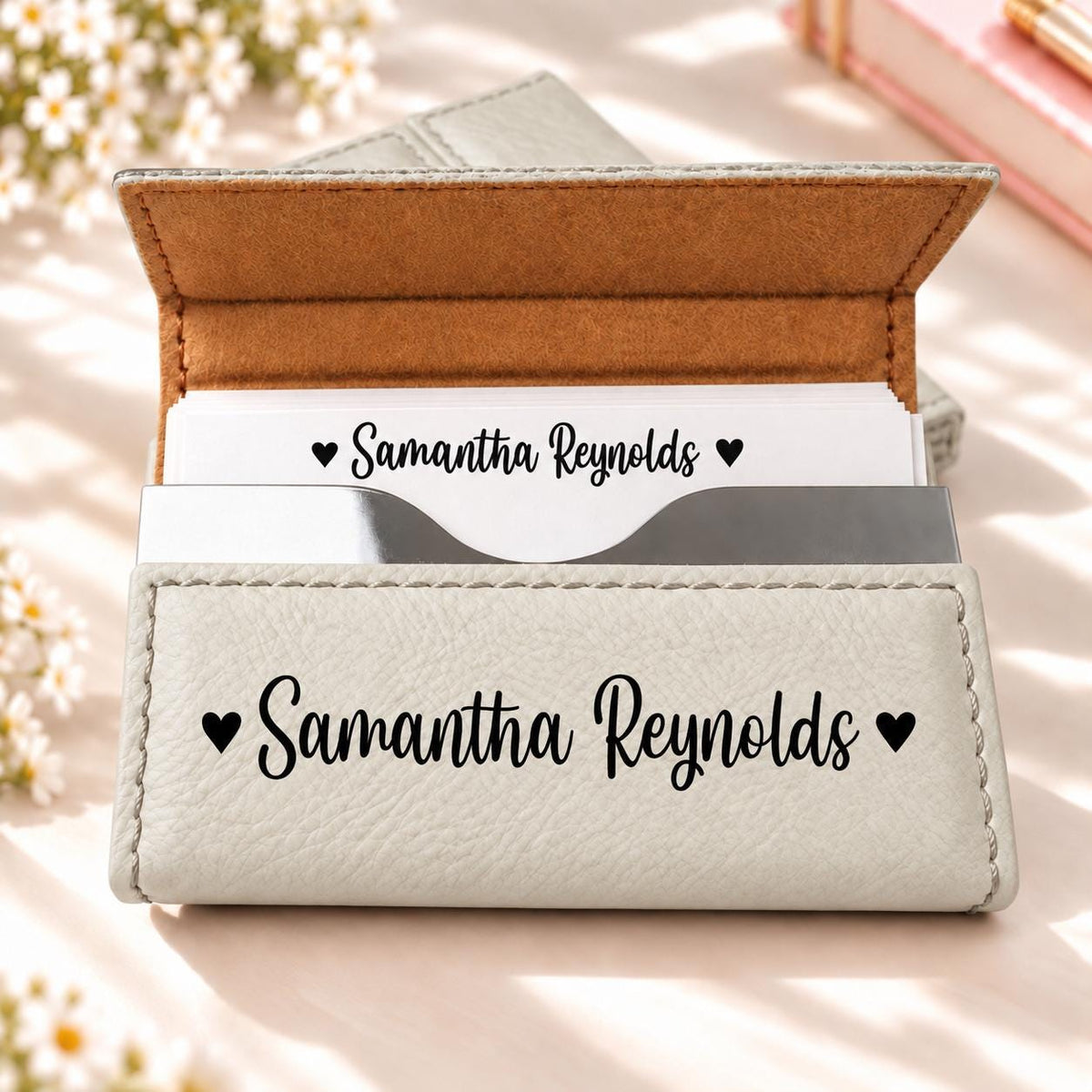 White business card holder engraved with a name and hearts
