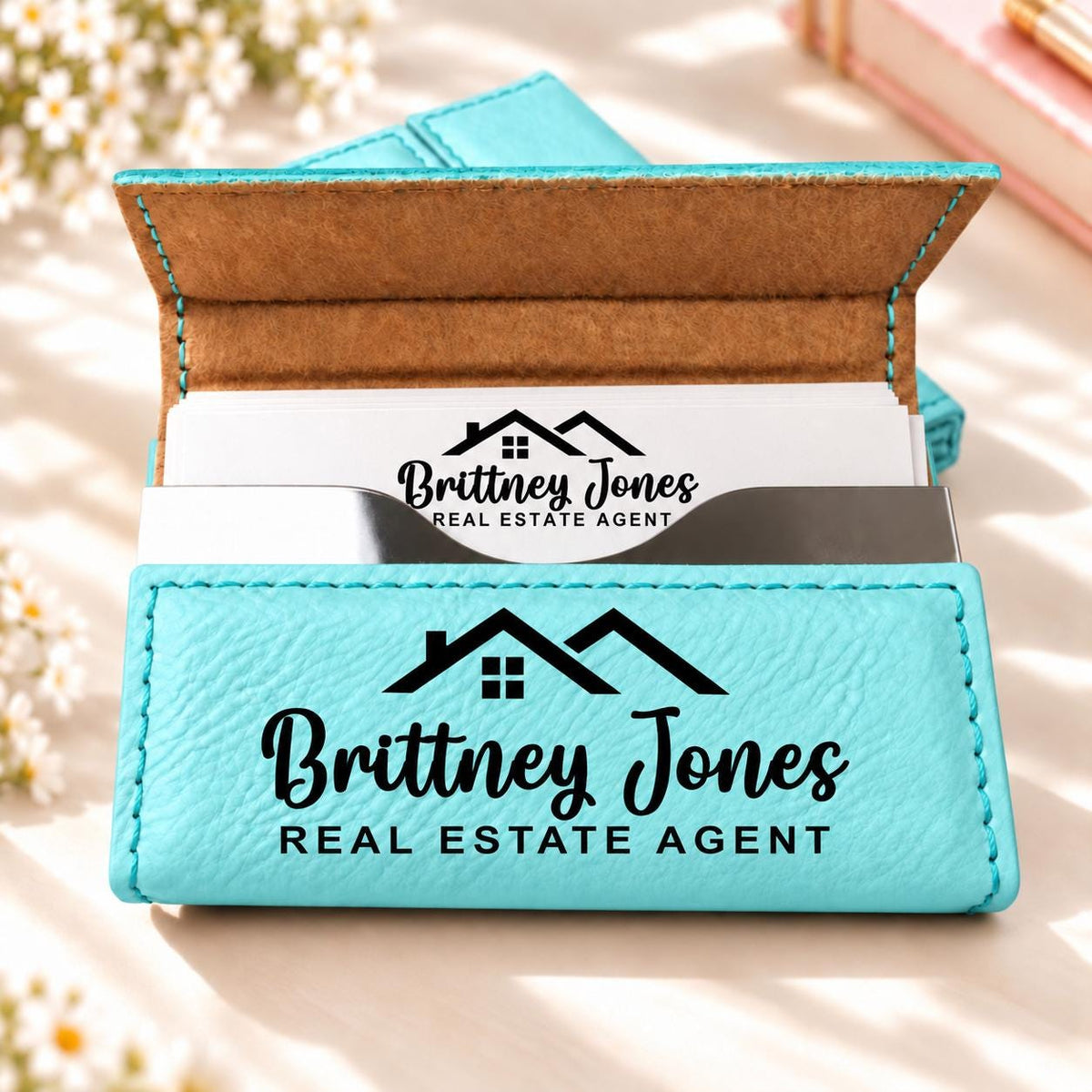 Teal business card holder engraved with a house design, name and title