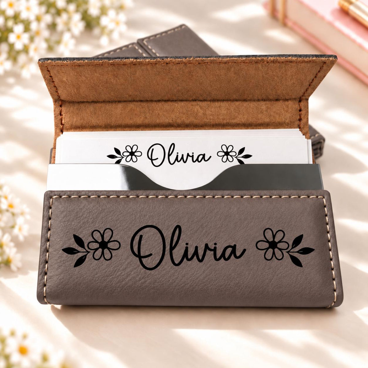 Grey business card holder engraved with a name and flowers
